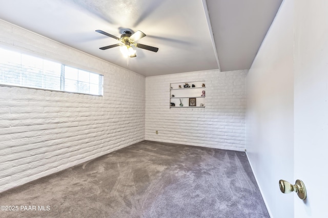2345 Shinnery Ln, Prescott, AZ 86301 - spare room featuring a ceiling fan, dark carpet, and brick wall