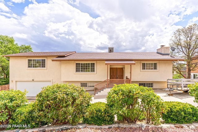 2345 Shinnery Ln, Prescott, AZ 86301 - raised ranch featuring stucco siding, an attached garage, and a chimney