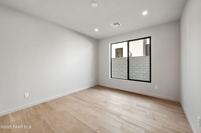 empty room featuring light wood-style flooring, baseboards, and recessed lighting