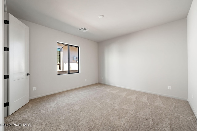 spare room with light colored carpet, visible vents, and baseboards