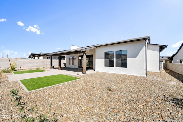 back of property with stucco siding, a fenced backyard, and a patio