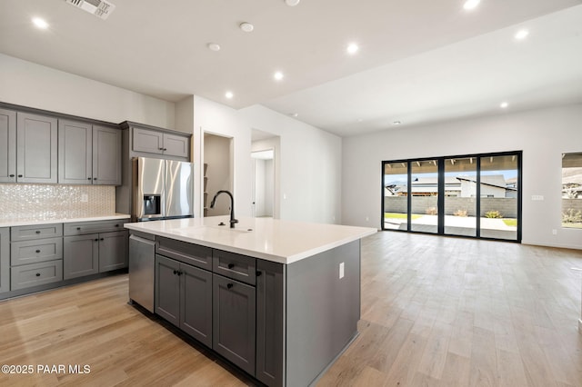 kitchen featuring gray cabinetry, appliances with stainless steel finishes, visible vents, and a sink