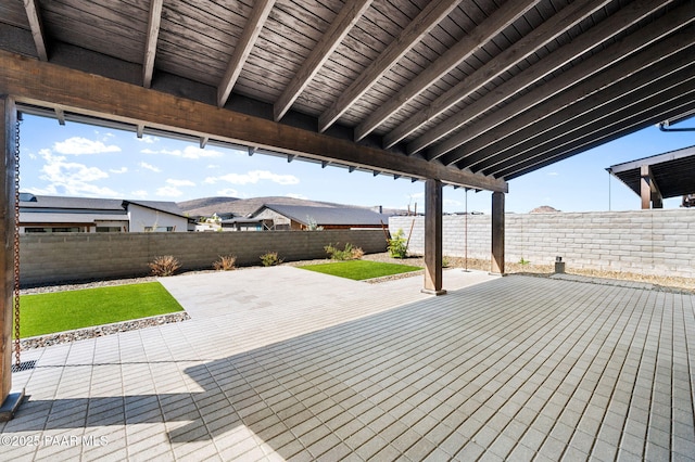 wooden deck featuring a yard, a patio area, and a fenced backyard