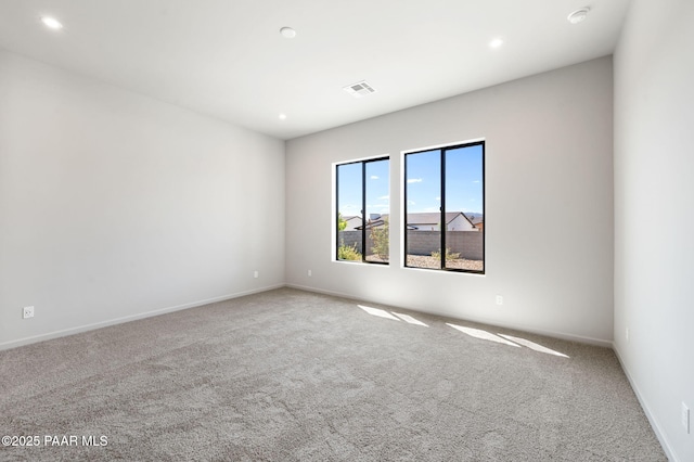 empty room with carpet, visible vents, and recessed lighting