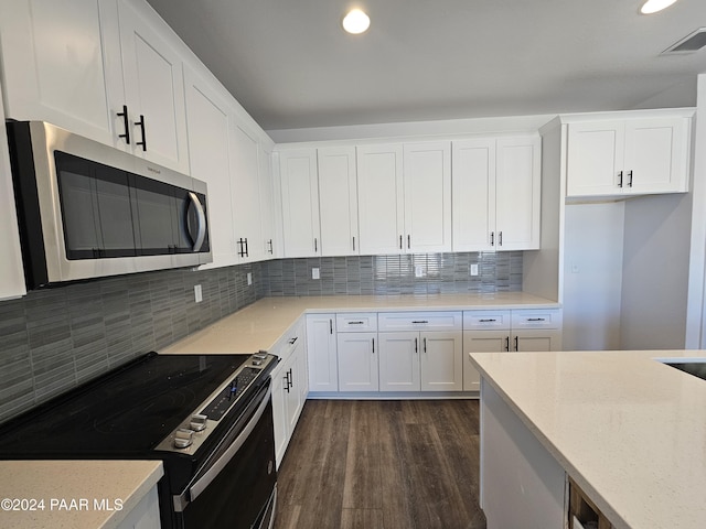 kitchen featuring backsplash, white cabinets, dark hardwood / wood-style floors, light stone countertops, and stainless steel appliances