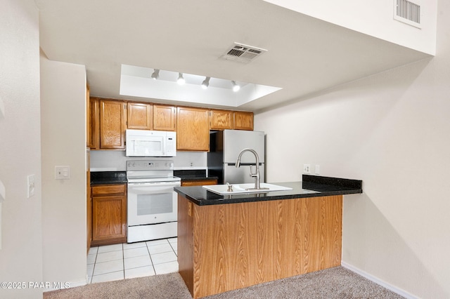 2180 Resort Way Unit S B, Prescott, AZ 86305 - kitchen featuring white appliances, a peninsula, a tray ceiling, dark countertops, and baseboards