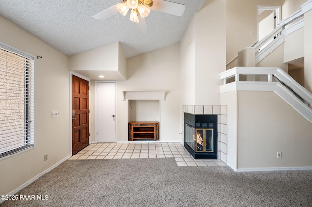2180 Resort Way Unit S B, Prescott, AZ 86305 - unfurnished living room with carpet flooring, a ceiling fan, vaulted ceiling, a tiled fireplace, and a textured ceiling
