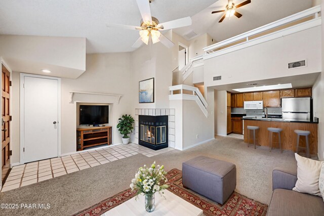 2180 Resort Way Unit S B, Prescott, AZ 86305 - living room featuring ceiling fan, light colored carpet, baseboards, high vaulted ceiling, and a tiled fireplace