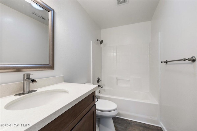 full bathroom with bathing tub / shower combination, vanity, hardwood / wood-style flooring, and toilet