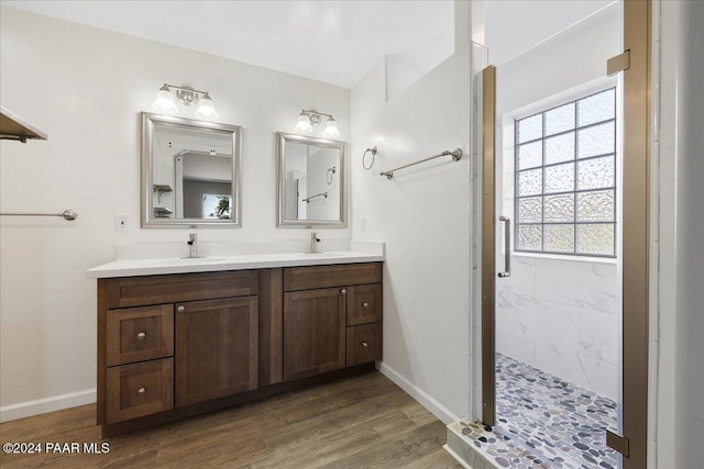 bathroom featuring tiled shower, wood-type flooring, and vanity