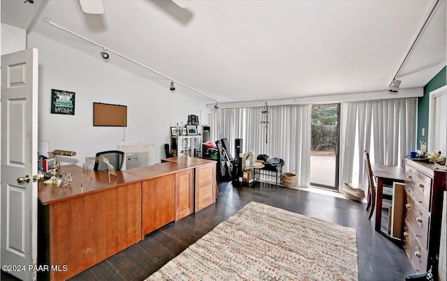 office space featuring dark hardwood / wood-style flooring, rail lighting, and vaulted ceiling