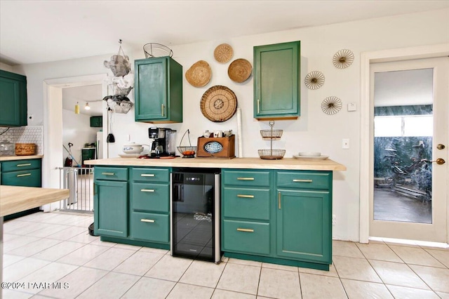 kitchen with tasteful backsplash, light tile patterned floors, beverage cooler, and green cabinetry