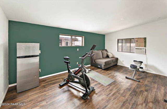 exercise room with vaulted ceiling and dark wood-type flooring