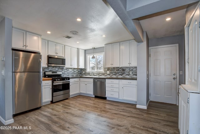 kitchen with light wood-style flooring, white cabinetry, and stainless steel appliances