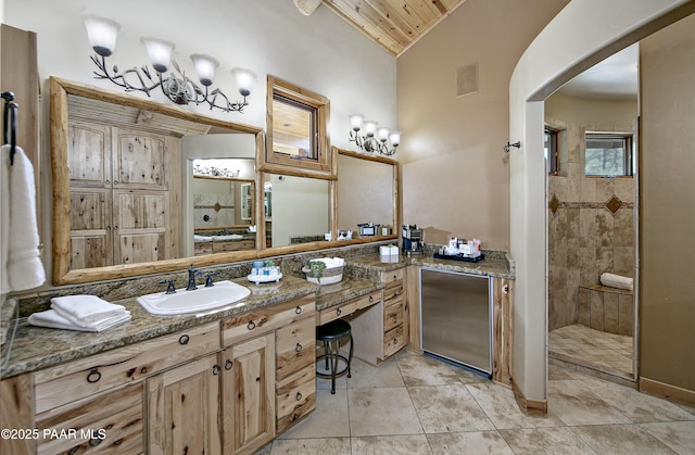 bathroom featuring lofted ceiling, vanity, tile patterned flooring, tiled shower, and wood ceiling