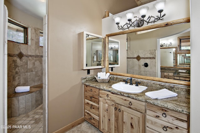 bathroom featuring tiled shower and vanity