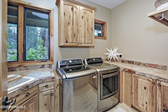 laundry room with cabinets, sink, and washing machine and dryer