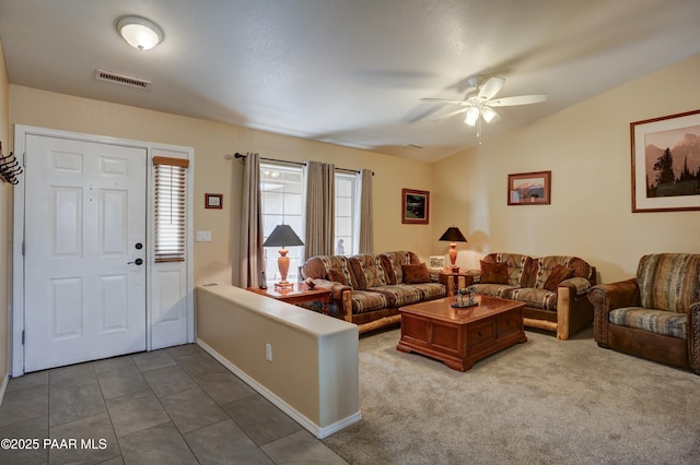 tiled living area featuring a ceiling fan, lofted ceiling, and visible vents