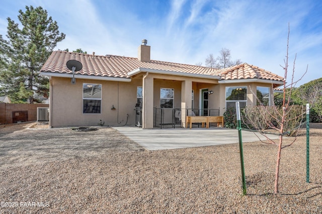 back of house featuring fence, a tile roof, stucco siding, a chimney, and a patio area