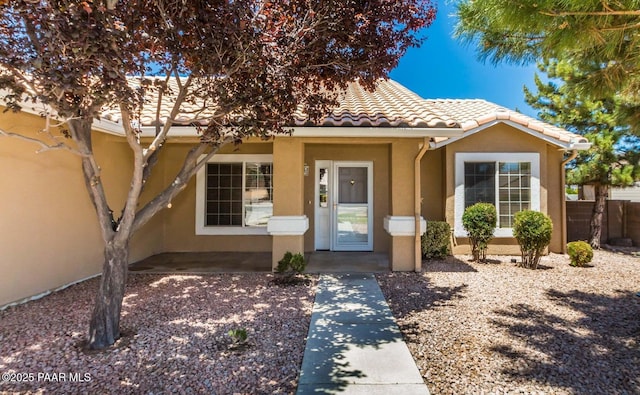 view of front of house featuring a tiled roof and stucco siding