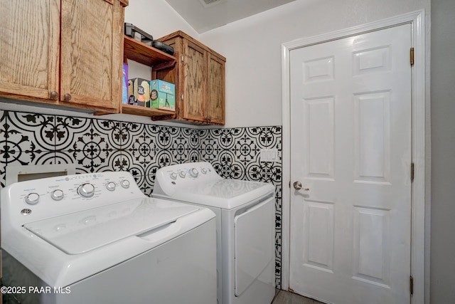 washroom with cabinet space and washer and clothes dryer