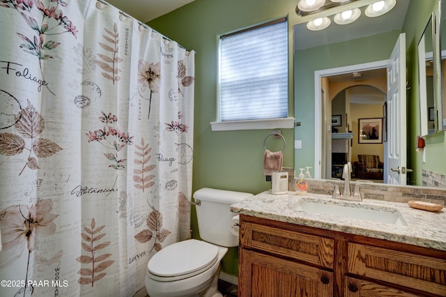 bathroom featuring curtained shower, vanity, and toilet