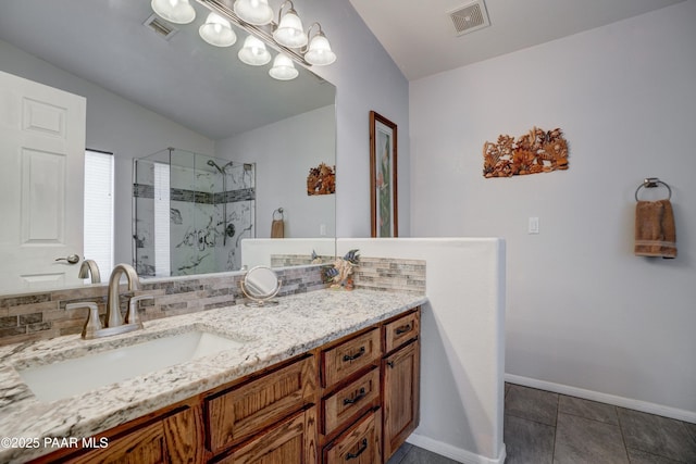 bathroom with vanity, a shower stall, visible vents, and baseboards