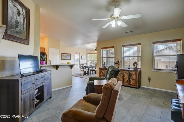 living room featuring light tile patterned floors, baseboards, visible vents, and a ceiling fan