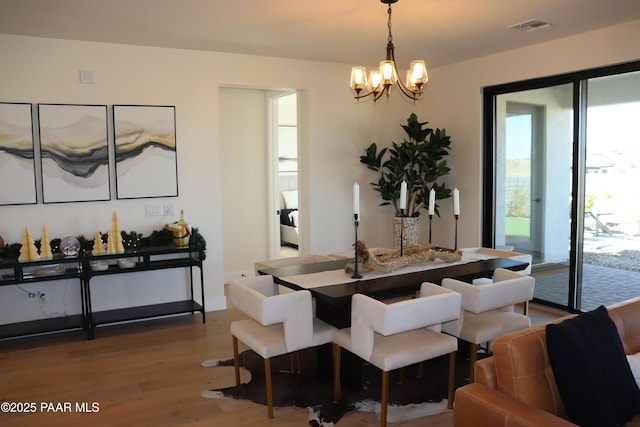 kitchen featuring a kitchen island with sink, stainless steel appliances, hardwood / wood-style floors, pendant lighting, and decorative backsplash