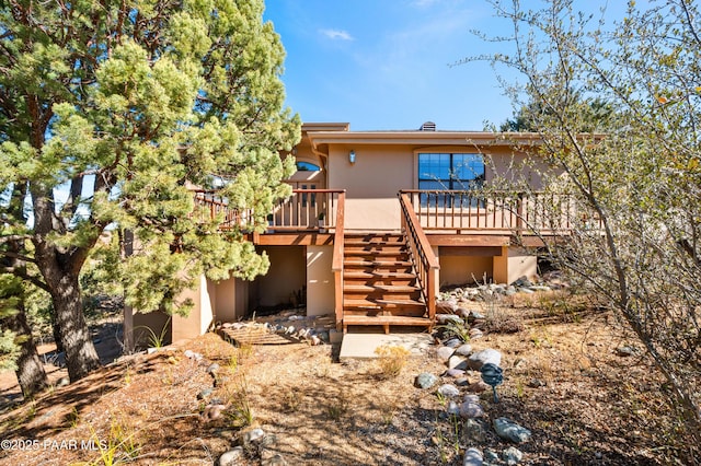 exterior space with stairs, a wooden deck, and stucco siding