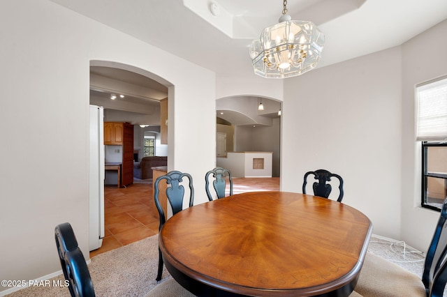 dining area featuring light tile patterned floors and a notable chandelier