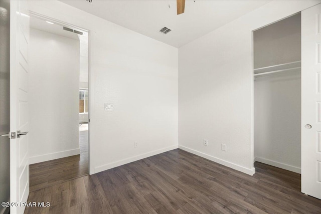 unfurnished bedroom featuring a closet, ceiling fan, and dark wood-type flooring