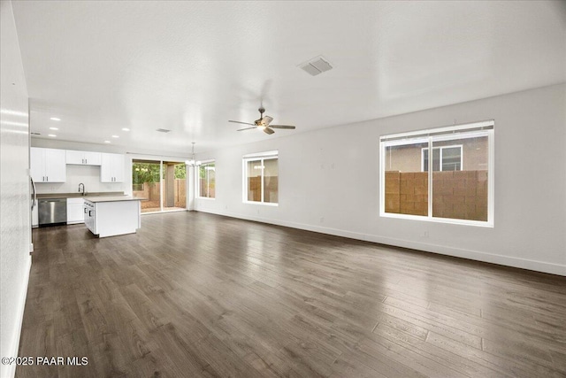 unfurnished living room featuring dark hardwood / wood-style floors, ceiling fan, and sink