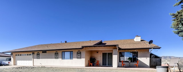 1086 N Broken Wagon Trl, Dewey-Humboldt, AZ 86327 - view of front of house with an attached garage, stucco siding, a chimney, and driveway