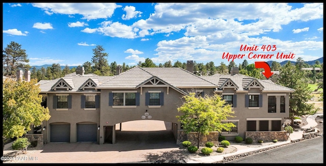 1716 Alpine Meadows Ln Unit 403, Prescott, AZ 86303 - view of front of property with stucco siding, an attached garage, driveway, a tile roof, and a chimney