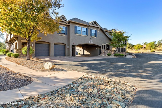 1716 Alpine Meadows Ln Unit 403, Prescott, AZ 86303 - view of front of house featuring stucco siding, gravel driveway, an attached garage, and stone siding