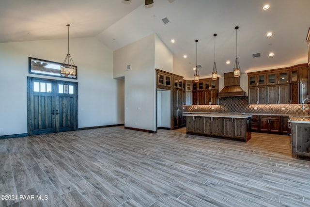 kitchen with a kitchen island, light hardwood / wood-style floors, and custom range hood