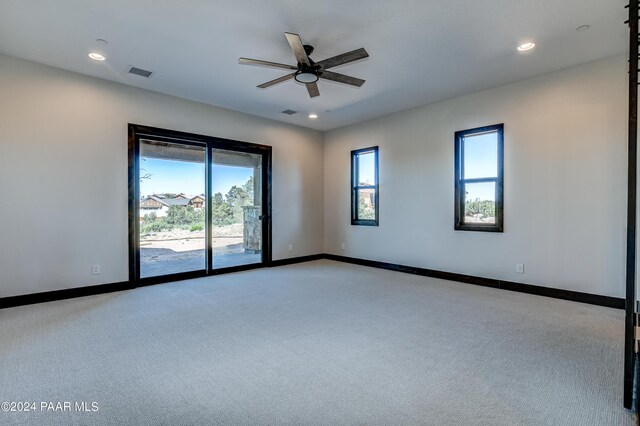 empty room featuring ceiling fan and light carpet