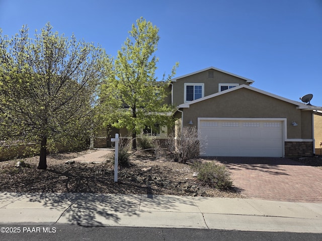 13085 E Ramos St, Dewey-Humboldt, AZ 86327 - view of front of home with a garage, stone siding, decorative driveway, and stucco siding