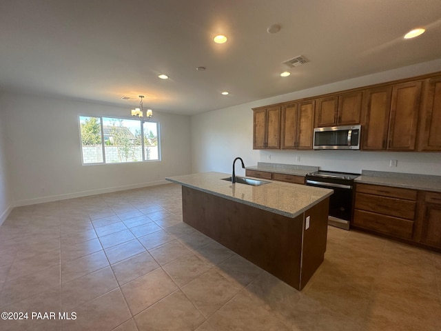 kitchen featuring sink, electric range, a center island with sink, a chandelier, and hanging light fixtures