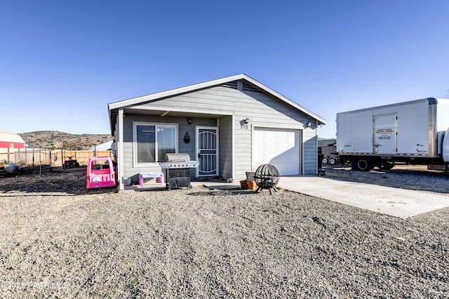 view of front of home featuring concrete driveway, an attached garage, and fence