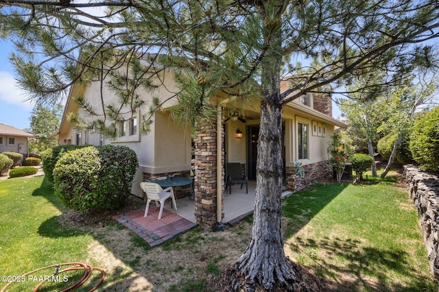 1222 Crown Ridge Dr, Prescott, AZ 86301 - rear view of house featuring stucco siding, stone siding, a patio, and a lawn