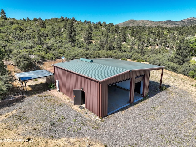 exterior space with a mountain view, an outdoor structure, and a garage