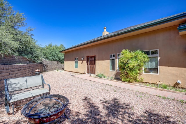 back of property with an outdoor fire pit