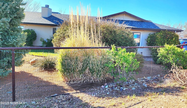 1125 N Wagon Wheel Pl, Chino Valley, AZ 86323 - view of side of home with a shingled roof, stucco siding, and a chimney