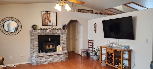1125 N Wagon Wheel Pl, Chino Valley, AZ 86323 - living room featuring lofted ceiling, a ceiling fan, wood finished floors, a brick fireplace, and baseboards