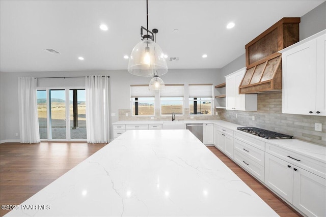 kitchen with light stone countertops, white cabinetry, and stainless steel appliances