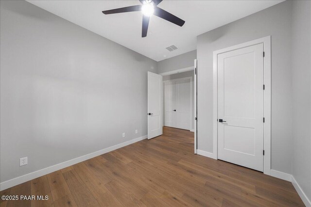 unfurnished bedroom featuring hardwood / wood-style flooring and ceiling fan