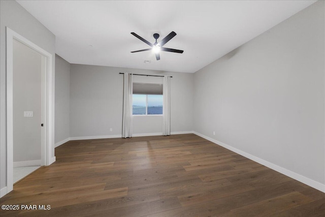 empty room with ceiling fan and dark wood-type flooring