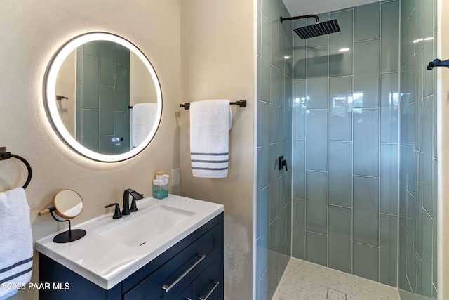 bathroom with vanity and tiled shower